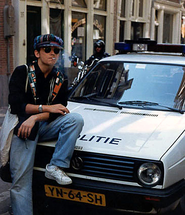 Guy smoking a joint on police car, Amsterdam, 1991
